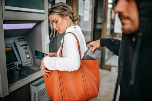 Man stealing money and personal stuff from woman - Visual concept for a criminal defense blog discussing larceny charges.