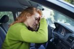 Stressed and tired woman at the wheel in her car worried she is getting a DUI/OWI Charge.