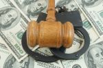 Wooden judge gavel and handcuffs on us dollars background Concept for post bail.