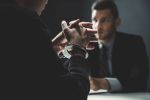 Criminal Charges: Man with handcuffs being interviewed in interrogation room. Visual concept for legal blog discussing Criminal Defense Law Firm Elmen Legal's legal experience and the types of cases they handle.